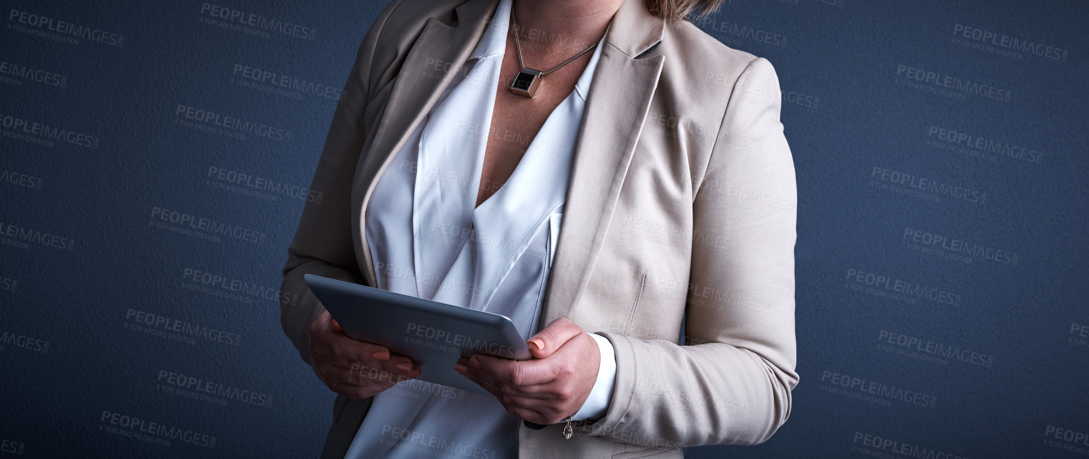 Buy stock photo Studio shot of an unrecognizable corporate businesswoman using a tablet against a dark background