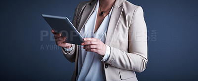 Buy stock photo Studio shot of an unrecognizable corporate businesswoman using a tablet against a dark background