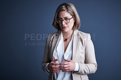 Buy stock photo Studio shot of an attractive young corporate businesswoman posing against a dark background