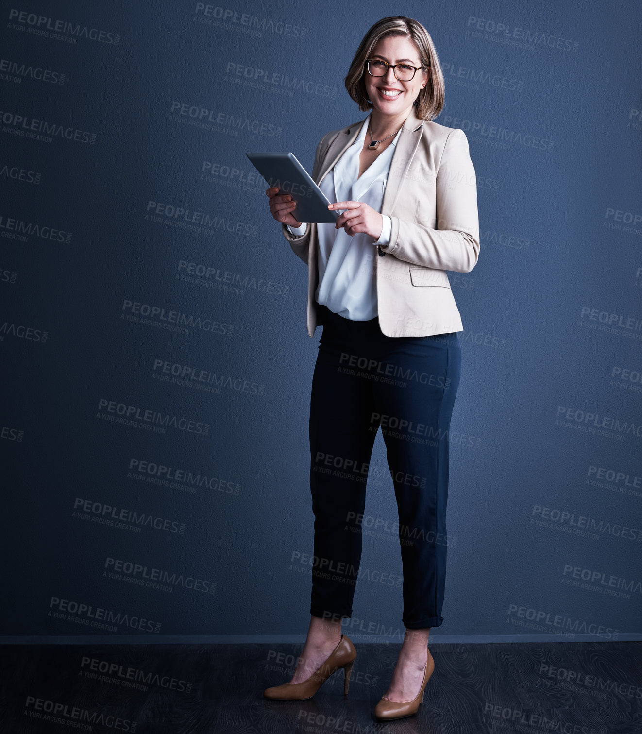 Buy stock photo Studio portrait of an attractive young corporate businesswoman using a tablet against a dark background