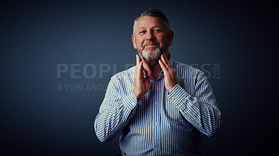 Buy stock photo Studio portrait of a mature businessman posing against a dark background