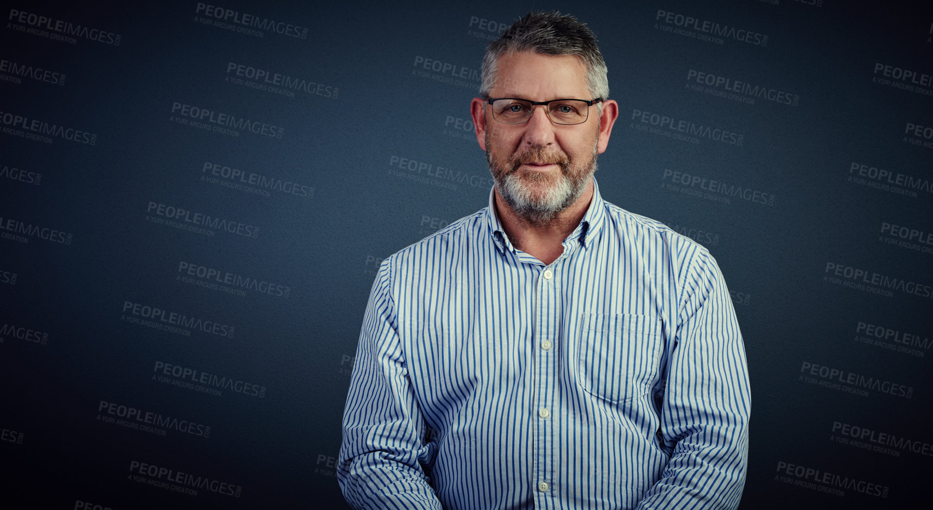 Buy stock photo Studio portrait of a mature businessman posing against a dark background