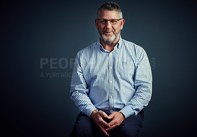 Buy stock photo Studio portrait of a mature businessman posing against a dark background