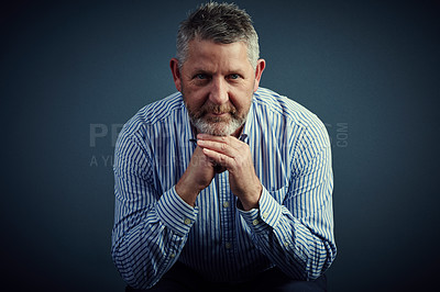 Buy stock photo Studio portrait of a confident and mature businessman looking thoughtful against a dark background