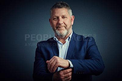 Buy stock photo Studio portrait of a confident and mature businessman buttoning his cuffs against a dark background