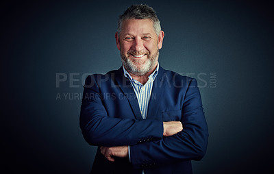 Buy stock photo Studio portrait of a confident and mature businessman standing with his arms folded against a dark background