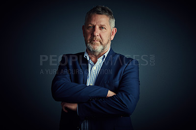 Buy stock photo Studio portrait of a confident and mature businessman standing with his arms folded against a dark background