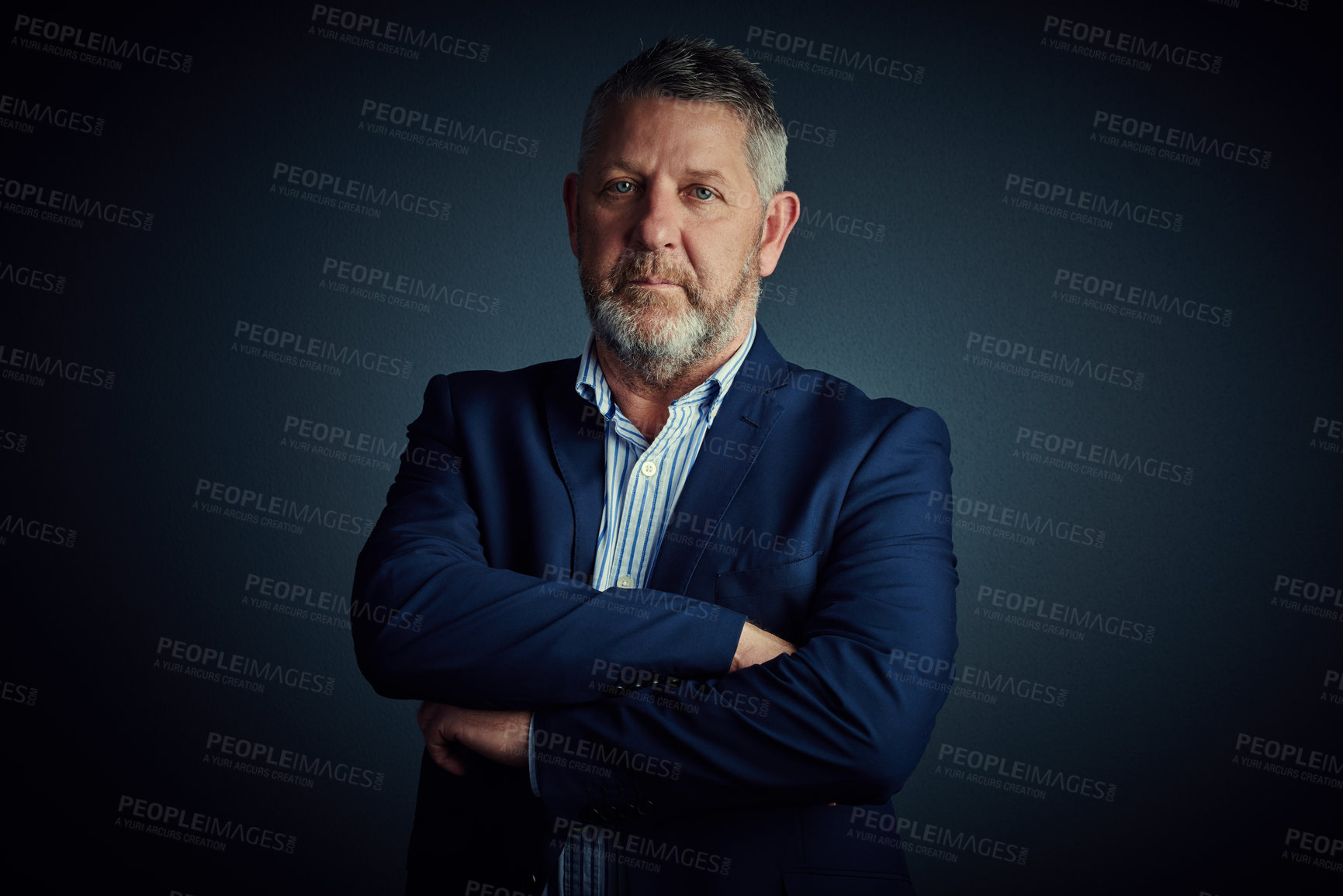 Buy stock photo Studio portrait of a confident and mature businessman standing with his arms folded against a dark background