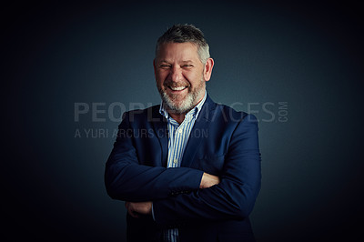 Buy stock photo Studio portrait of a confident and mature businessman standing with his arms folded against a dark background