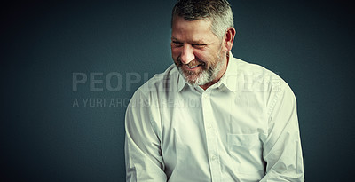 Buy stock photo Studio shot of a handsome mature businessman looking thoughtful while sitting down against a dark background