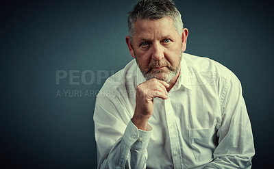 Buy stock photo Studio portrait of a handsome mature businessman looking thoughtful while sitting down against a dark background