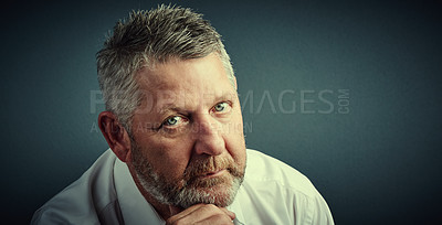 Buy stock photo Studio portrait of a handsome mature businessman looking thoughtful while sitting down against a dark background