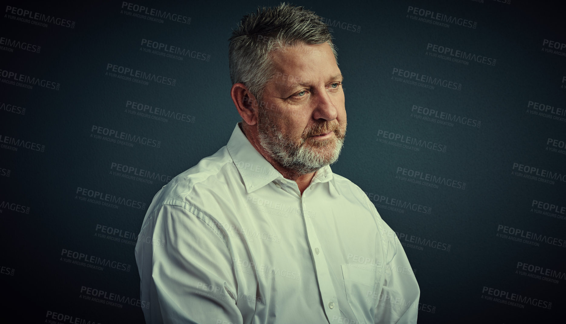 Buy stock photo Studio shot of a handsome mature businessman looking thoughtful while sitting down against a dark background