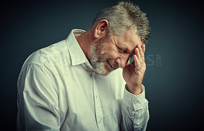 Buy stock photo Studio shot of a mature businessman looking stressed while sitting down against a dark background