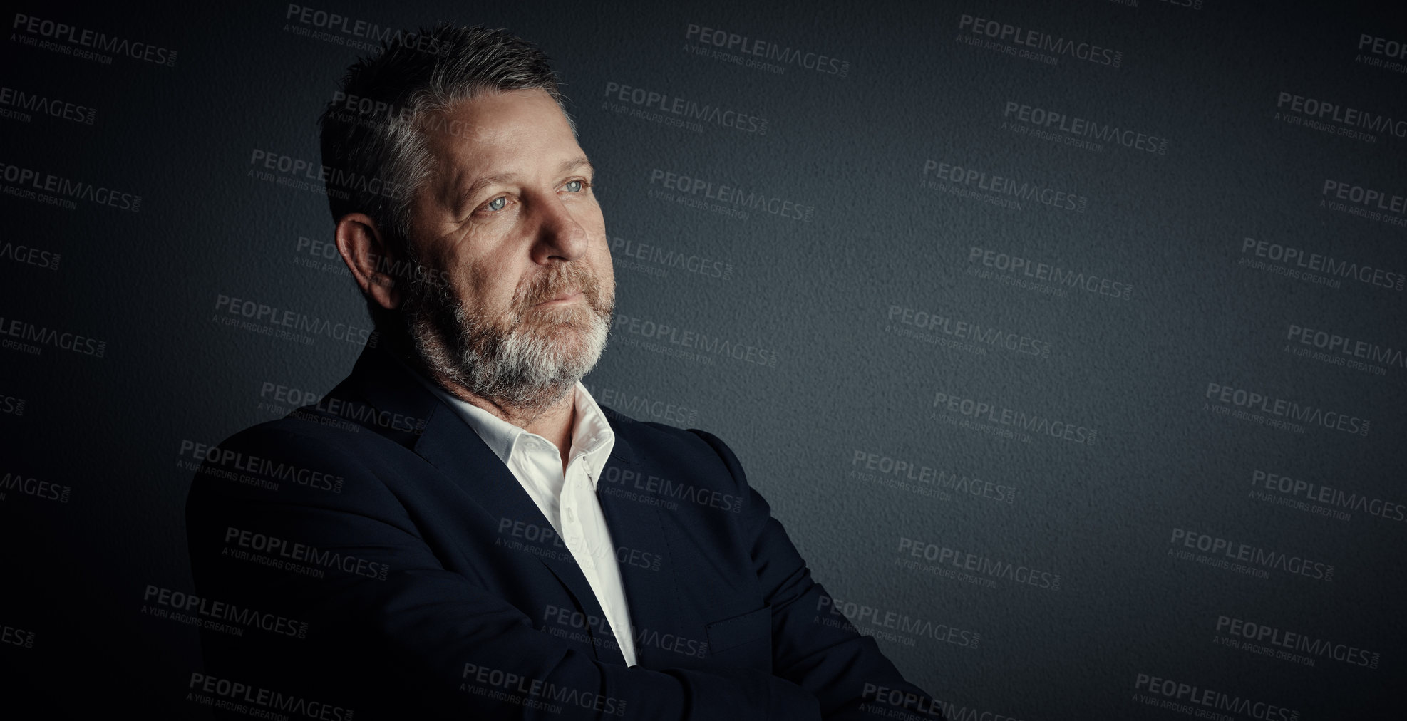 Buy stock photo Studio shot of a handsome mature businessman looking thoughtful while standing against a dark background