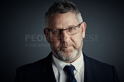 Buy stock photo Studio portrait of a handsome mature businessman standing against a dark background