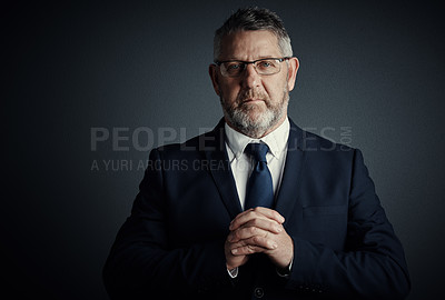 Buy stock photo Studio portrait of a handsome mature businessman standing against a dark background