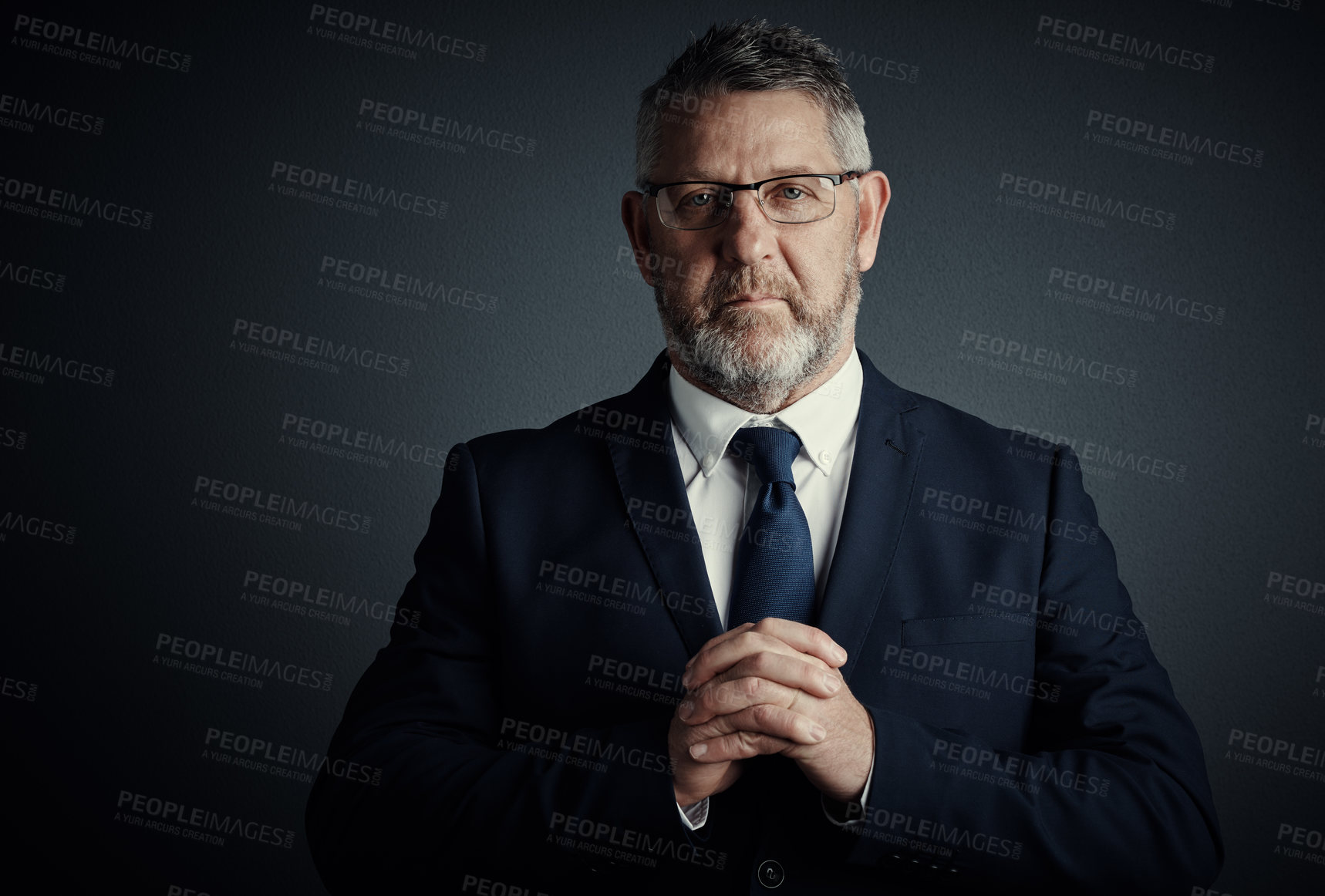 Buy stock photo Studio portrait of a handsome mature businessman standing against a dark background