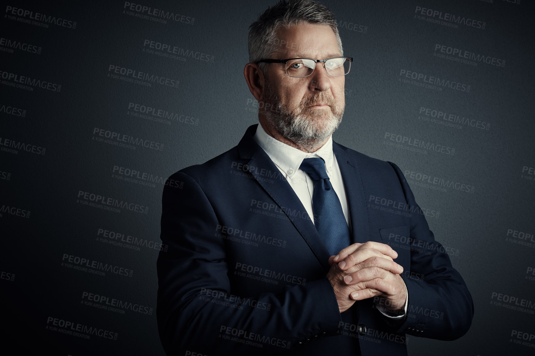 Buy stock photo Studio portrait of a handsome mature businessman standing against a dark background