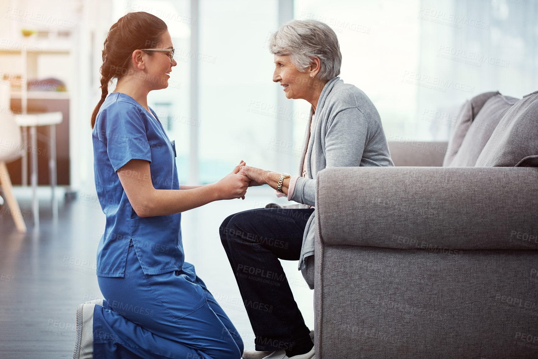 Buy stock photo Cropped shot of a young female nurse talking to her senior patient in the old age home