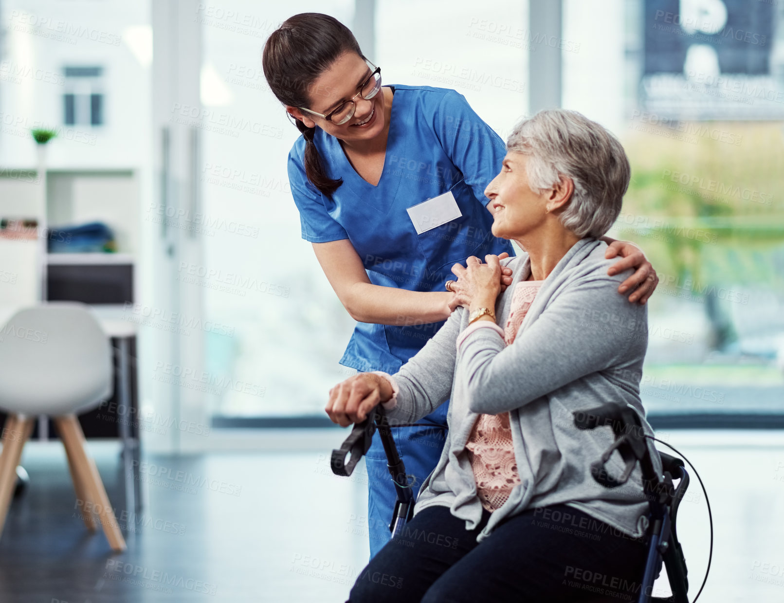 Buy stock photo Cropped shot of a young female nurse talking to her senior patient in the old age home