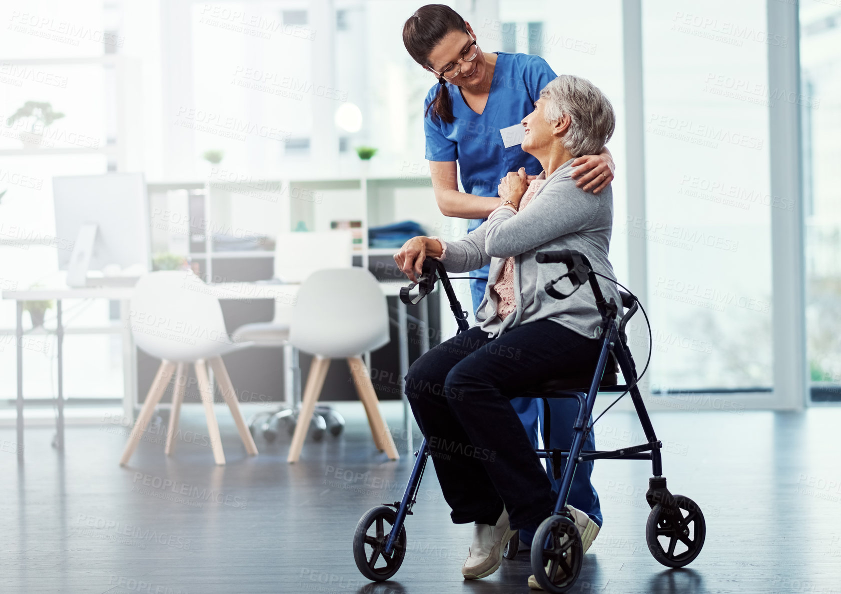 Buy stock photo Full length shot of a young female nurse talking to her senior patient in the old age home