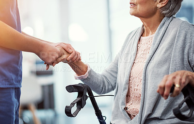 Buy stock photo Cropped shot of an unrecognizable female nurse holding her senior patient's hand in comfort
