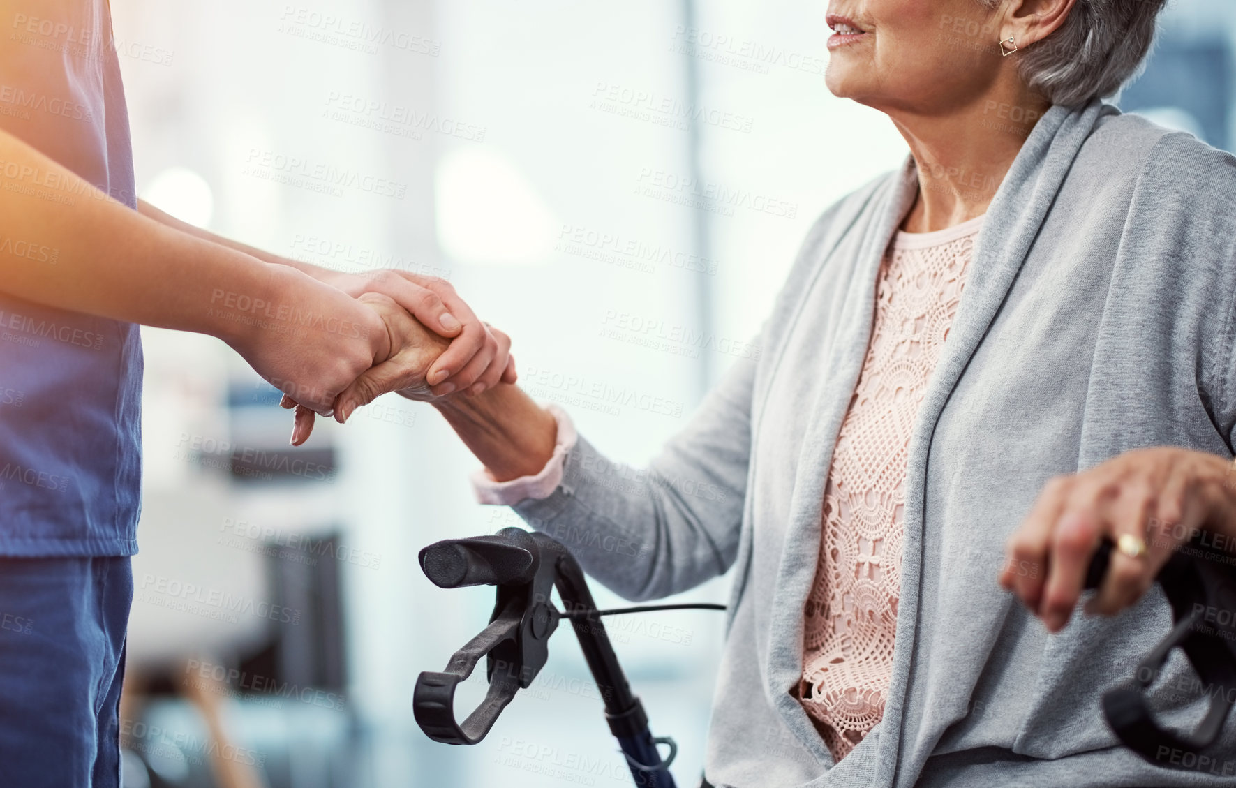 Buy stock photo Cropped shot of an unrecognizable female nurse holding her senior patient's hand in comfort