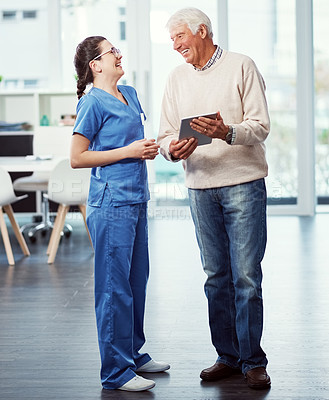 Buy stock photo Full length shot of a young female nurse and her senior patient looking at a tablet in the old age home