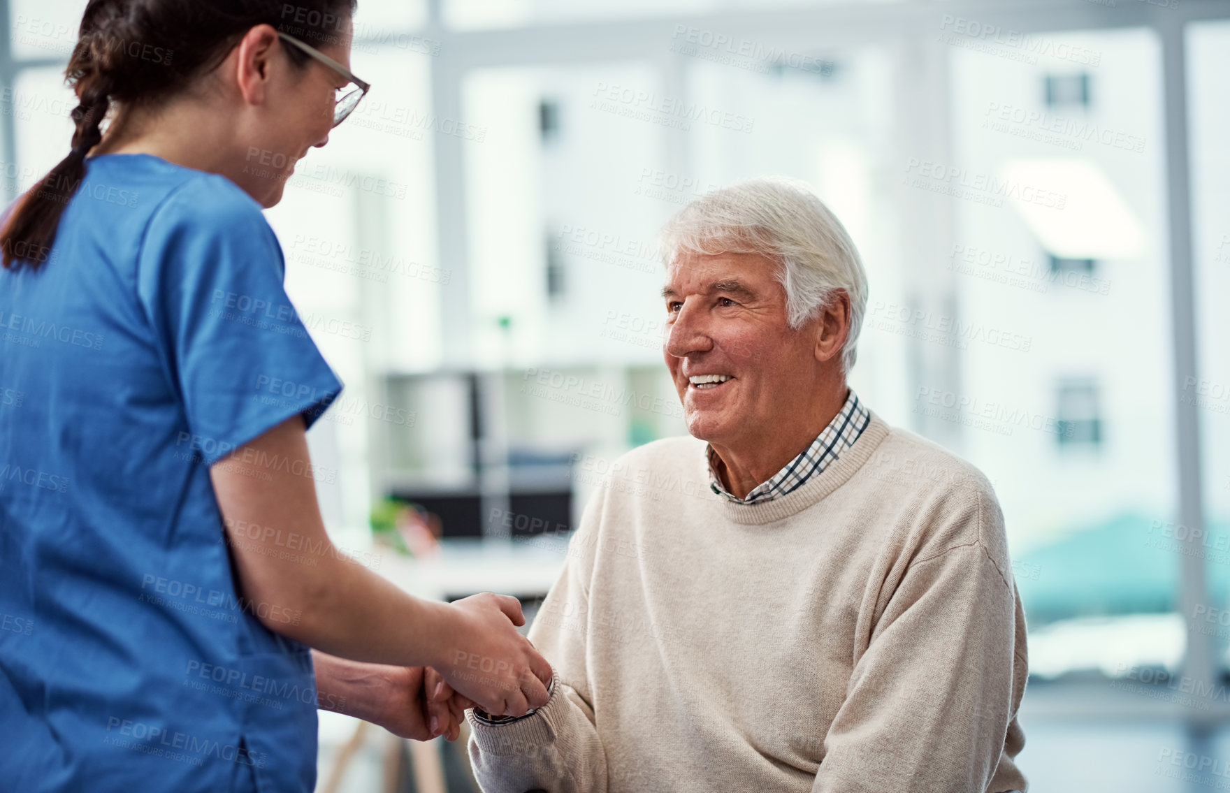 Buy stock photo Cropped shot of a young female nurse talking to her senior patient in the old age home