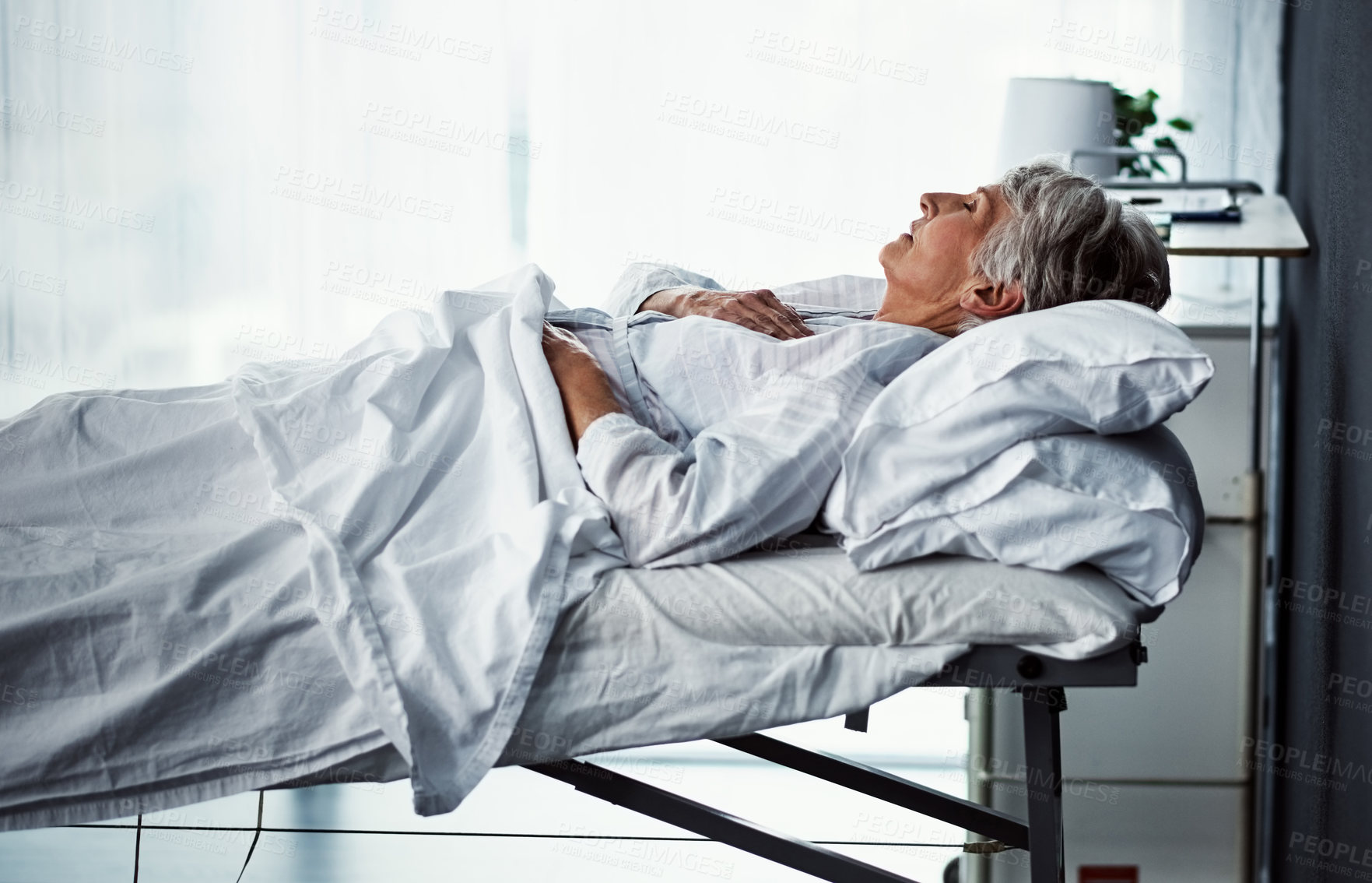 Buy stock photo Cropped shot of a sickly senior woman lying in a hospital bed