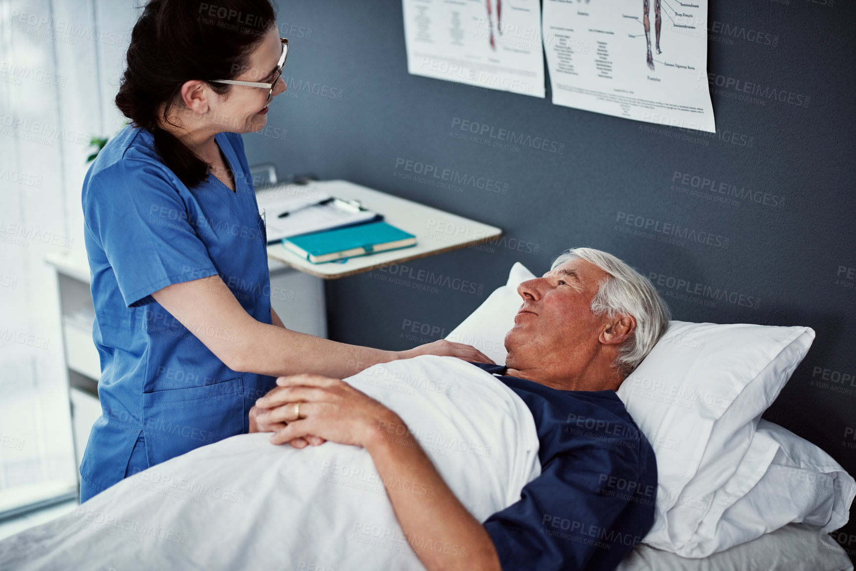 Buy stock photo High angle shot of a female carer assisting her male patient in a nursing home