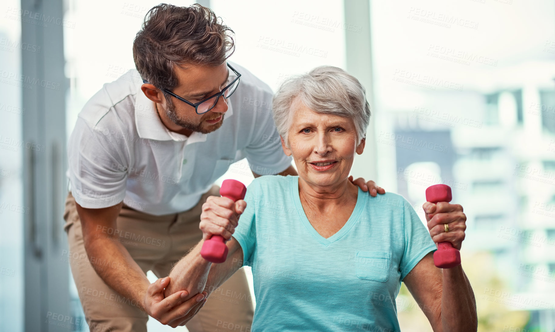 Buy stock photo Cropped portrait of a senior woman working through her recovery with a male physiotherapist