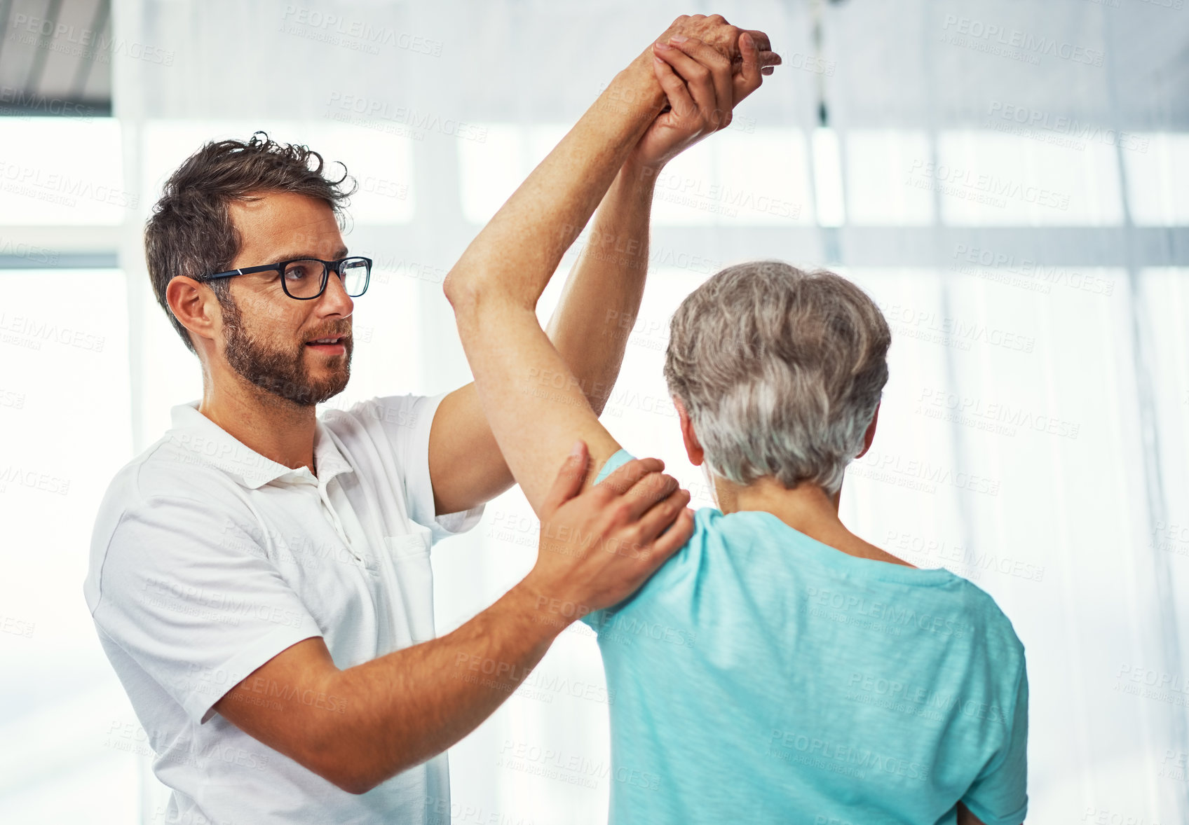 Buy stock photo Cropped shot of a senior woman working through her recovery with a male physiotherapist