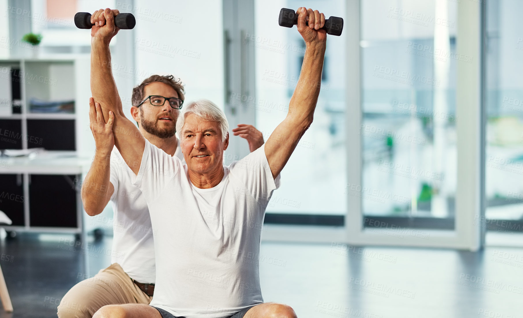 Buy stock photo Clinic, physiotherapist and senior man with dumbbells, fitness and assistance for workout or health. Training, old person and physical therapy with equipment for wellness, exercise and rehabilitation