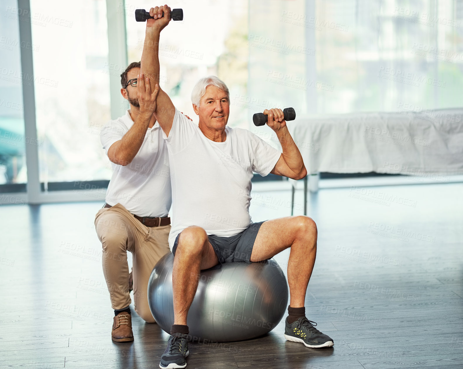 Buy stock photo Full length shot of a senior man working on his recovery with a male physiotherapist
