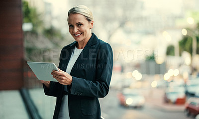 Buy stock photo Cropped portrait of an attractive mature businesswoman using her tablet while standing on the balcony of her office