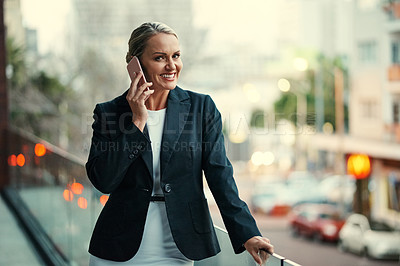 Buy stock photo Cropped portrait of an attractive mature businesswoman using her cellphone while standing on the balcony of her office