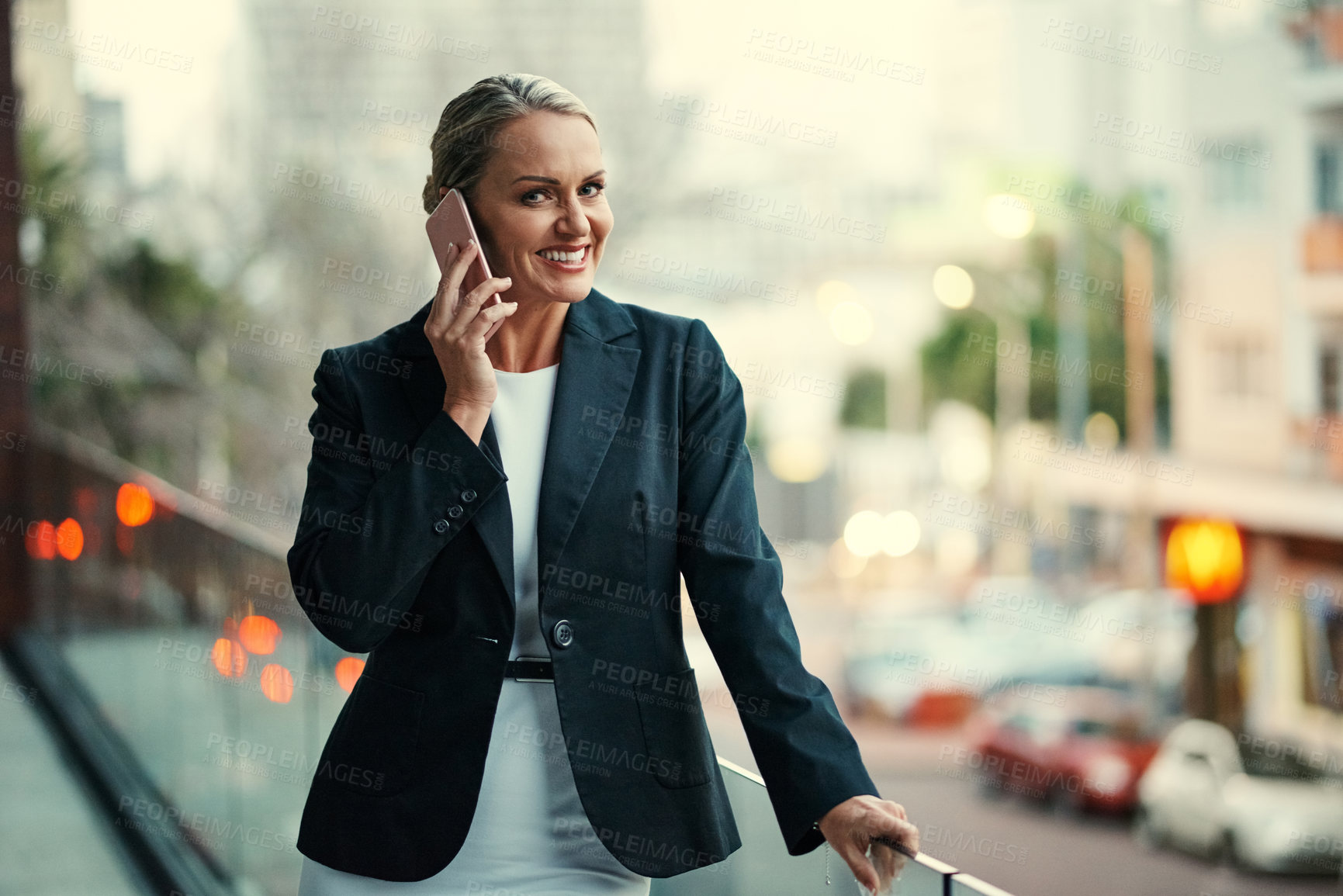 Buy stock photo Cropped portrait of an attractive mature businesswoman using her cellphone while standing on the balcony of her office