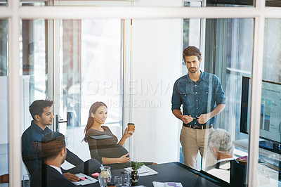 Buy stock photo High angle shot of a young businessman giving a presentation in the boardroom