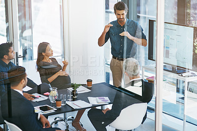 Buy stock photo High angle shot of a young businessman giving a presentation in the boardroom
