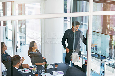 Buy stock photo High angle shot of a young businessman giving a presentation in the boardroom