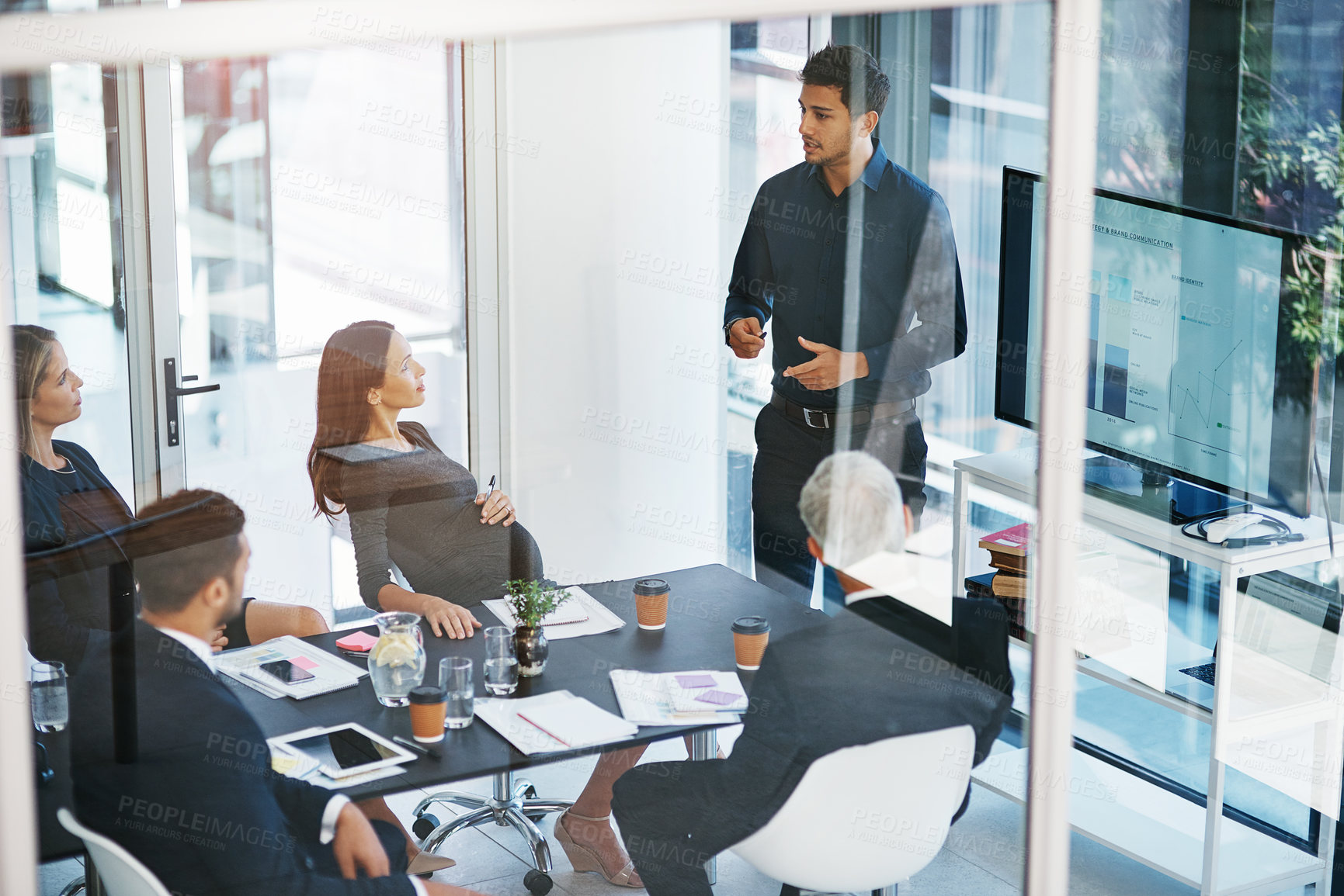 Buy stock photo High angle shot of a young businessman giving a presentation in the boardroom