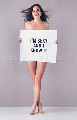 Buy stock photo Studio portrait of an attractive young woman holding a sign that reads “I'm sexy and I know it” against a pink background