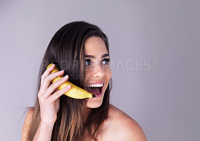 Buy stock photo Phone call, banana and woman in studio for skincare, beauty and organic face routine with gossip. Surprise, mockup space and female person with pretend conversation with fruit by gray background.