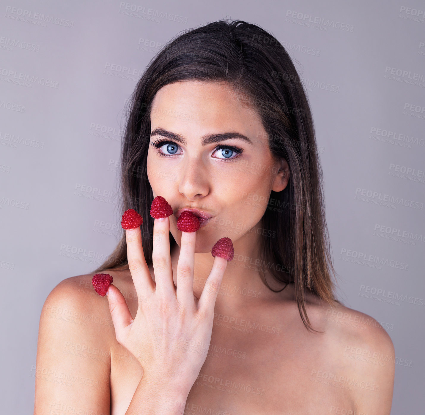 Buy stock photo Woman, portrait and fingers for raspberry skincare in studio, organic beauty and gray background. Female person, fruit and vegan cosmetics product for smooth skin, dermatology and sustainable diet