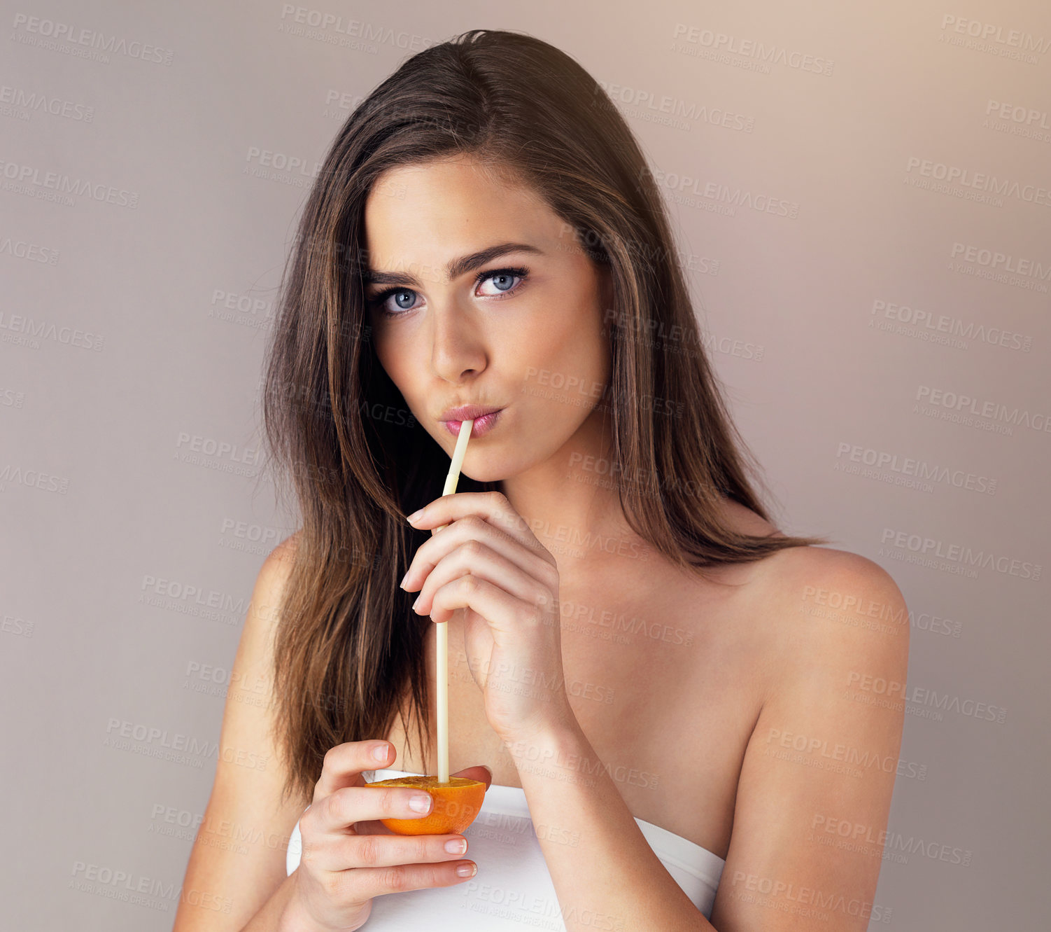 Buy stock photo Woman, portrait and drinking orange in studio, fresh juice and nutrition on gray background. Female person, raw fruit and straw for vitamin c diet or healthy detox, organic and fiber antioxidant