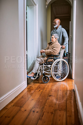 Buy stock photo Cropped shot of a senior man pushing his wheelchair-bound wife through the house