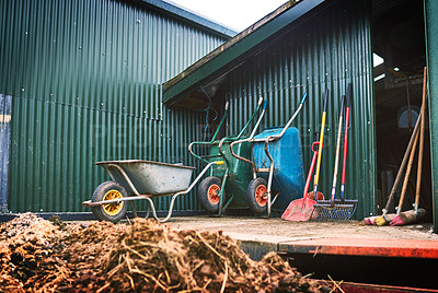 Buy stock photo Shot of farming tools against a barn outside 