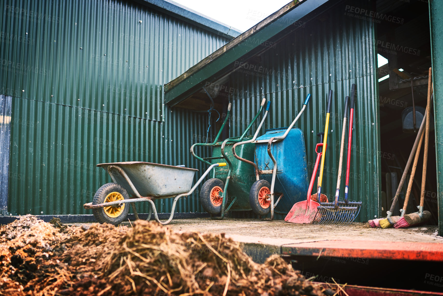 Buy stock photo Shot of farming tools against a barn outside 